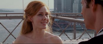 Movie still from “Enchanted” (2007), directed by Kevin Lima – A beautiful young woman standing on top of a sandy beach; Close Up shot, Over the shoulder angle