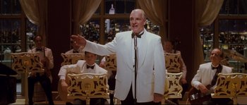 Movie still from “Enchanted” (2007), directed by Kevin Lima – A man wearing a white suit and a bow tie; Medium shot, Low angle