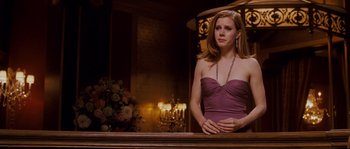 Movie still from “Enchanted” (2007), directed by Kevin Lima – A woman in a purple dress standing in front of candles; Medium shot, Low angle