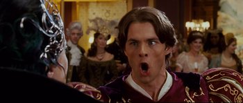 Movie still from “Enchanted” (2007), directed by Kevin Lima – A man with his mouth wide open in front of a group of people; Close Up shot, Over the shoulder angle