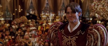 Movie still from “Enchanted” (2007), directed by Kevin Lima – A man standing in front of a crowd of people; Medium shot, Over the shoulder angle