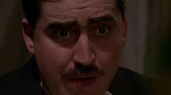 Movie still from “Enchanted April” (1991), directed by Mike Newell – A person wearing a suit and mustache; Close Up shot, Low angle