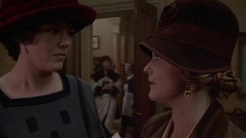 Movie still from “Enchanted April” (1991), directed by Mike Newell – Two women wearing hats are talking to each other in a room; Close Up shot, Over the shoulder angle