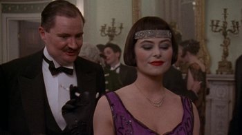 Movie still from “Enchanted April” (1991), directed by Mike Newell – A man and a woman in formal wear at a formal event; Close Up shot, Over the shoulder angle