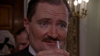 Movie still from “Enchanted April” (1991), directed by Mike Newell – A person holding a glass of water; Close Up shot, High angle