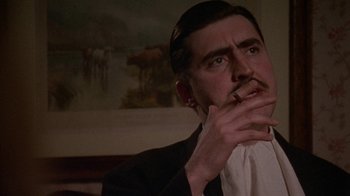 Movie still from “Enchanted April” (1991), directed by Mike Newell – A man in a black suit smoking a cigarette; Close Up shot, Low angle