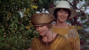 Movie still from “Enchanted April” (1991), directed by Mike Newell – Two women wearing hats standing next to each other; Medium shot, Over the shoulder angle