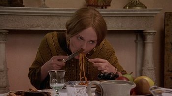 Movie still from “Enchanted April” (1991), directed by Mike Newell – A woman is eating spaghetti at a dinner table; Close Up shot, High angle