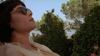 Movie still from “Enchanted April” (1991), directed by Mike Newell – A woman wearing sunglasses looking up into the sky; Close Up shot, High angle