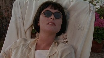 Movie still from “Enchanted April” (1991), directed by Mike Newell – A woman wearing sunglasses laying on the ground; Close Up shot, Low angle
