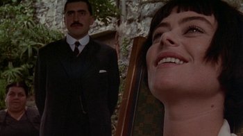 Movie still from “Enchanted April” (1991), directed by Mike Newell – A man and a woman in a suit and tie in front of a building; Close Up shot, Over the shoulder angle