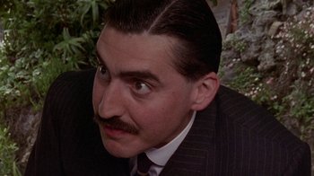 Movie still from “Enchanted April” (1991), directed by Mike Newell – A person wearing a suit and tie; Close Up shot, Low angle