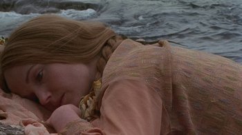 Movie still from “Enchanted April” (1991), directed by Mike Newell – A young girl is laying on the ground near the water; Close Up shot, High angle