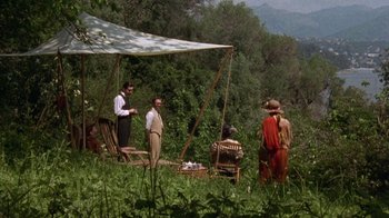 Movie still from “Enchanted April” (1991), directed by Mike Newell – A group of people standing around in a field; Wide shot, High angle
