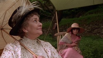 Movie still from “Enchanted April” (1991), directed by Mike Newell – Two women sitting on a bench wearing hats; Close Up shot, Over the shoulder angle