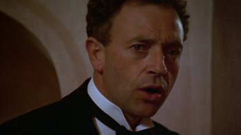 Movie still from “Enchanted April” (1991), directed by Mike Newell – A person wearing a suit and tie; Close Up shot, Low angle