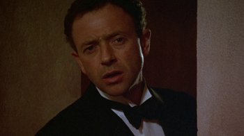Movie still from “Enchanted April” (1991), directed by Mike Newell – A person wearing a suit and a bow tie; Close Up shot, Low angle