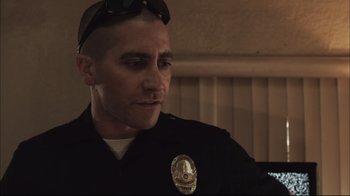 Movie still from “End of Watch” (2012), directed by David Ayer – A man in a police uniform is looking at the camera; Close Up shot, Over the shoulder angle
