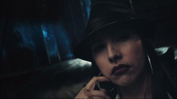 Movie still from “End of Watch” (2012), directed by David Ayer – A woman in a black hat is talking on a cell phone; Close Up shot, Low angle