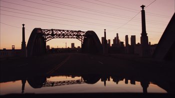 Movie still from “End of Watch” (2012), directed by David Ayer – A view of a bridge from a car window at dusk; Extreme Wide shot, High angle