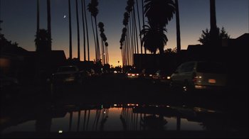 Movie still from “End of Watch” (2012), directed by David Ayer – Cars are driving down a street at dusk; Extreme Wide shot, Low angle
