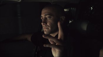 Movie still from “End of Watch” (2012), directed by David Ayer – A man in a black shirt is holding his hand up; Close Up shot, Low angle
