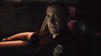 Movie still from “End of Watch” (2012), directed by David Ayer – A police officer sitting in a car at night; Close Up shot, Over the shoulder angle