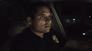Movie still from “End of Watch” (2012), directed by David Ayer – A police officer sitting in the back of a car; Close Up shot, Low angle