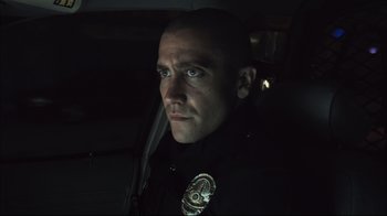 Movie still from “End of Watch” (2012), directed by David Ayer – A police officer in a car at night looking into the camera; Close Up shot, Low angle