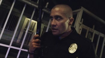 Movie still from “End of Watch” (2012), directed by David Ayer – A police officer holding a gun in his hand; Close Up shot, Low angle