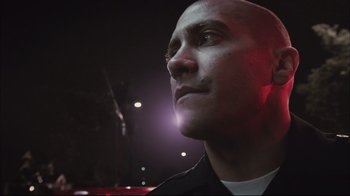 Movie still from “End of Watch” (2012), directed by David Ayer – A man with a bald head looking up at the sky; Close Up shot, Low angle