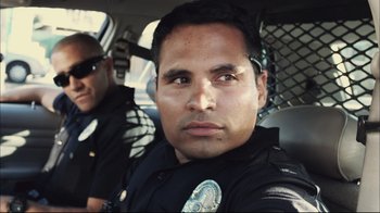 Movie still from “End of Watch” (2012), directed by David Ayer – Two police officers sitting in the back of a patrol car; Close Up shot, Low angle