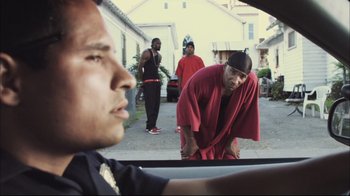 Movie still from “End of Watch” (2012), directed by David Ayer – A group of men standing next to each other in the back of a car; Medium shot, Over the shoulder angle