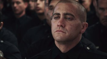 Movie still from “End of Watch” (2012), directed by David Ayer – A person wearing a black uniform; Close Up shot, Over the shoulder angle