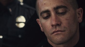 Movie still from “End of Watch” (2012), directed by David Ayer – A person with his eyes closed; Close Up shot, Over the shoulder angle
