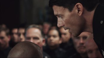 Movie still from “End of Watch” (2012), directed by David Ayer – A crowd of people are gathered around a man's face; Close Up shot, Over the shoulder angle