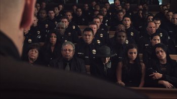 Movie still from “End of Watch” (2012), directed by David Ayer – A large group of police officers sitting in front of a crowd of onlookers; Wide shot, High angle