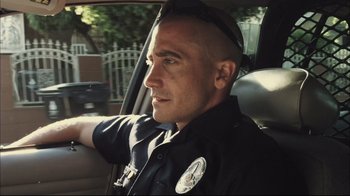 Movie still from “End of Watch” (2012), directed by David Ayer – A police officer sitting in the back of a car; Close Up shot, Low angle