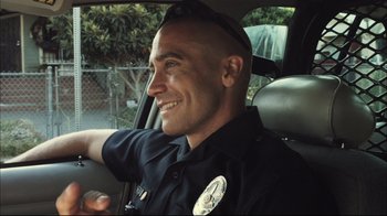 Movie still from “End of Watch” (2012), directed by David Ayer – A police officer sitting in the drivers seat of a car; Close Up shot, Low angle