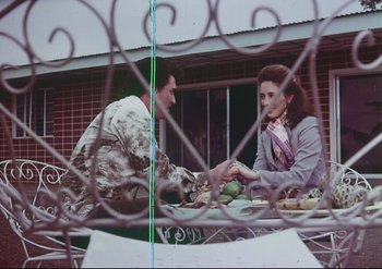 Movie still from “Enforcer from Death Row” (1976), directed by Efren C. Piñon – A man and a woman sitting at an outdoor table; Medium shot, High angle
