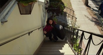 Movie still from “Enough Said” (2013), directed by Nicole Holofcener – A woman is kneeling down on the stairs; Wide shot, High angle