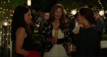 Movie still from “Enough Said” (2013), directed by Nicole Holofcener – A group of people standing next to each other holding drinks; Medium shot, Over the shoulder angle
