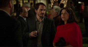 Movie still from “Enough Said” (2013), directed by Nicole Holofcener – A man and a woman standing next to each other; Medium shot, Over the shoulder angle