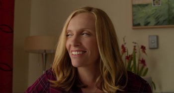 Movie still from “Enough Said” (2013), directed by Nicole Holofcener – A person with long blonde hair smiling; Close Up shot, Over the shoulder angle
