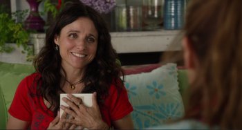 Movie still from “Enough Said” (2013), directed by Nicole Holofcener – Julia louis - dreyfus is smiling while holding a cup of coffee; Close Up shot, Over the shoulder angle