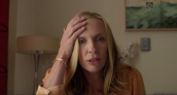 Movie still from “Enough Said” (2013), directed by Nicole Holofcener – A person holding her hand up to her forehead; Close Up shot, High angle