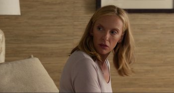 Movie still from “Enough Said” (2013), directed by Nicole Holofcener – A woman with long blonde hair is looking at the camera; Close Up shot, Over the shoulder angle