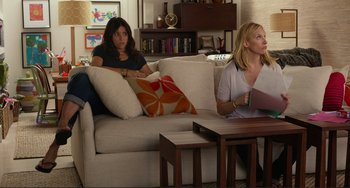 Movie still from “Enough Said” (2013), directed by Nicole Holofcener – Two women sitting on a couch in a living room; Wide shot, Over the shoulder angle