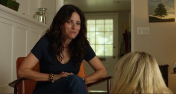 Movie still from “Enough Said” (2013), directed by Nicole Holofcener – A woman sitting in a chair in front of another woman; Medium shot, Over the shoulder angle