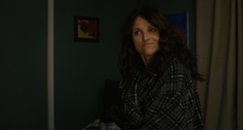 Movie still from “Enough Said” (2013), directed by Nicole Holofcener – A woman sitting in front of a mirror in a room; Medium shot, Over the shoulder angle